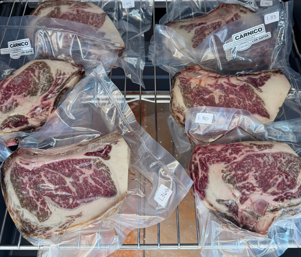 Packaged steaks on a metal rack with a kitchen background